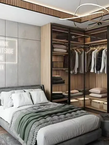 This bedroom design includes a glass-walled walk-in closet, making the space feel larger while showcasing the wardrobe.