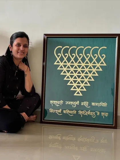 When the frame is so huge you have to sit down to hold it! This is another large, custom-ordered Saraswati frame with a gold yantra on a green background.