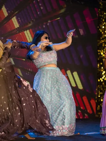 The bride's squad puts on a coordinated dance performance, complete with sunglasses, for a fun Sangeet act.