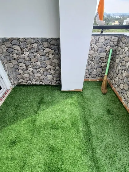 This balcony features our artificial grass paired with a stone-patterned wall cladding, creating a rustic and natural look.
