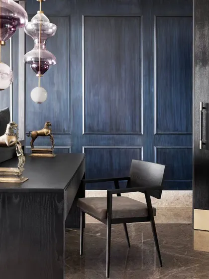 Another shot of the integrated desk, showing the beautiful grain of the wood against the deep blue paneling. This is luxury residential design that is both beautiful and practical.