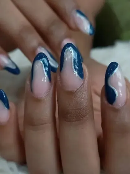 A close-up of the artistic deep blue abstract swirl nails.