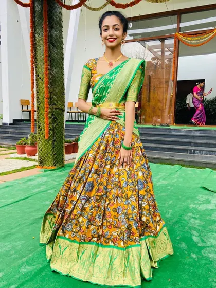 This custom Kalamkari half saree is a celebration of traditional Indian textiles. The printed skirt is paired with a simple green blouse and a beautiful Banarasi georgette dupatta for a rich, artistic look.
