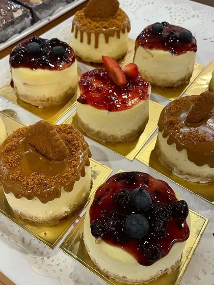 A tray of our assorted mini baked cheesecakes. These individual portions are perfect for parties or when you want to sample different toppings like Biscoff, blueberry, and strawberry.