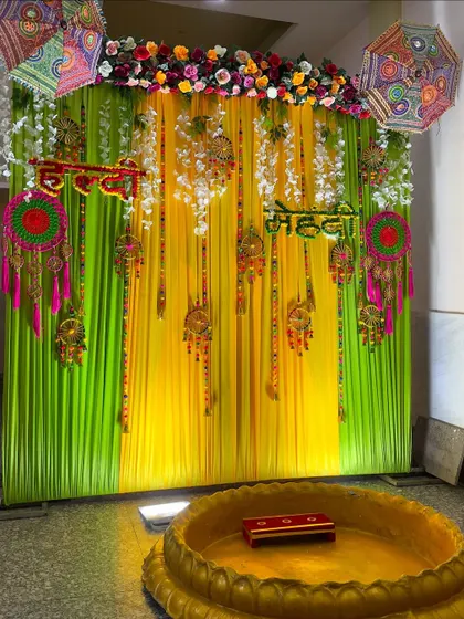 A beautiful backdrop for a joint Haldi and Mehendi ceremony. I use signs for both functions, with a mix of hanging tassels, dreamcatchers, and floral elements.