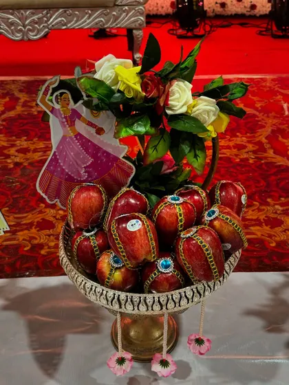A decorated platter of apples with a cutout of a dancing girl, adding a festive touch.
