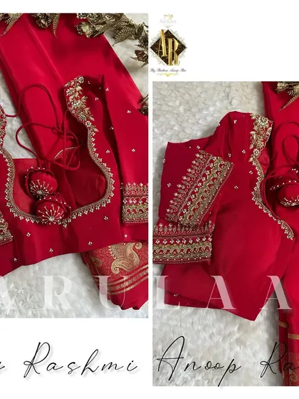 A classic red bridal blouse with heavy "descending work" on the sleeves, where the embroidery flows down from the shoulder. The blouse is finished with large, custom-made ball latkans.