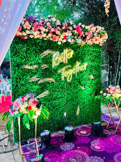 'Better Together' says it all. This photo booth features a vibrant green wall, a custom neon sign, and a colorful floral header, creating a lively and fun spot for guests.