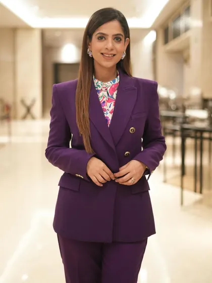 A closer look at the purple blazer. The sharp tailoring and bold color project confidence and energy.
