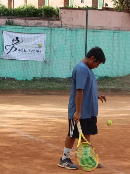 A player getting ready to hit a serve, focusing on the ball toss and preparation.