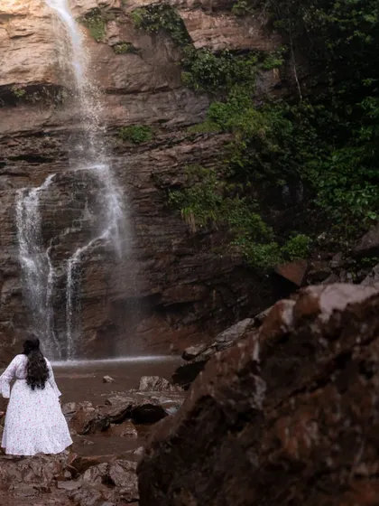 The bride-to-be standing before a stunning waterfall, creating a powerful and serene portrait. We use natural wonders as a backdrop to add a sense of grandeur to our photos.