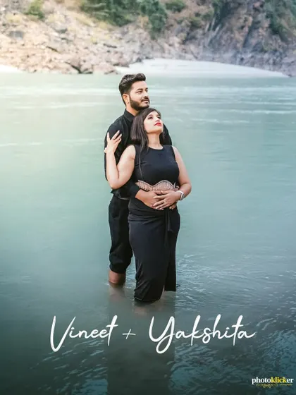 A serene and romantic shot of a couple standing in the calm river waters, embracing as they look out towards the horizon.