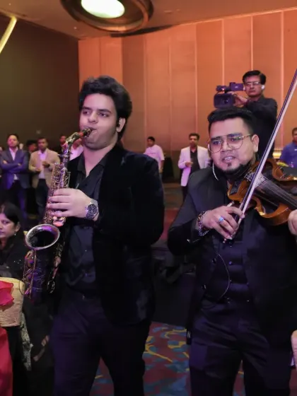 A customized musician flashmob in action, surprising guests at a corporate awards function. Here, a saxophonist and violinist move through the audience, creating an intimate and interactive musical experience.