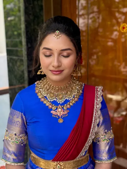 A close-up on the details of a traditional Telugu look. The eye makeup is soft and shimmery, paired with a natural lip, letting the exquisite temple jewellery take center stage.