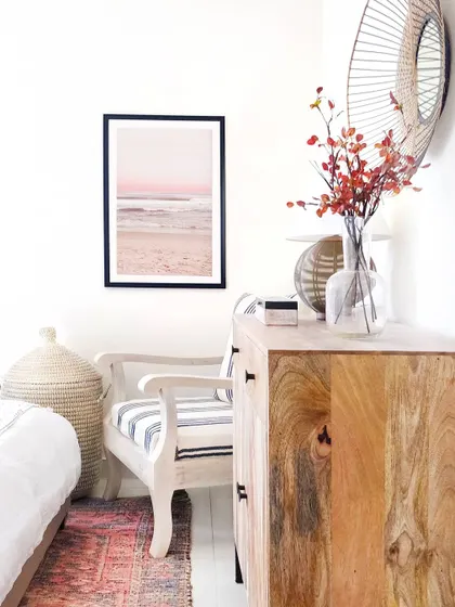 No bedroom is complete without a cozy corner to curl up with a book. In this room, I used a distressed wood armchair, a rustic dresser, and soft textiles to create a quiet moment for escape and relaxation.