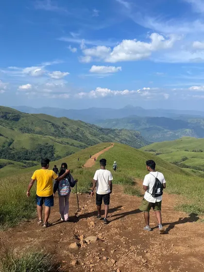 Our trekkers walking along the vast, open trail of Netravathi, with endless hills in the distance.