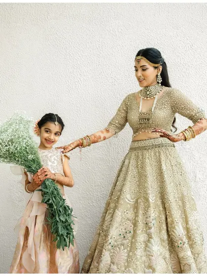 A sweet moment between the bride and a flower girl, with the bride's stained henna visible.