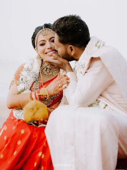 A sweet kiss on the cheek, a candid and loving gesture captured during their wedding rituals.