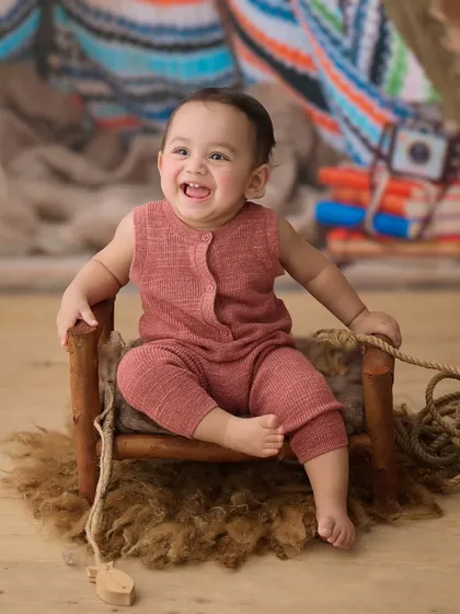 This little camper is all smiles. The rustic props and textures in this setup create a warm and adventurous outdoor feel.