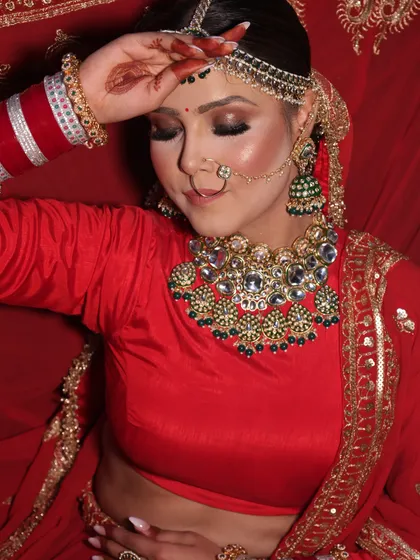 This image captures the soft, romantic side of a bridal look. With eyes gently closed, you can appreciate the smooth blending of the eyeshadow and the flawless, airbrushed finish on the skin.