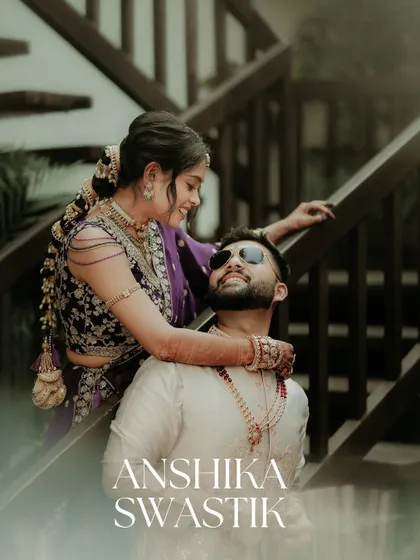 A stylish and modern couple portrait. The bride drapes her arm around the groom, both looking cool and confident, with clean text overlay adding a magazine-like quality.