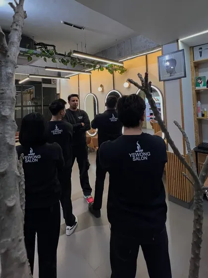 A team huddle at the salon. We regularly meet to discuss techniques and ensure we are all aligned on providing the best possible service to our clients.
