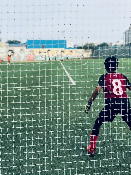 Eyes on the ball, hands ready for the challenge. A young goalkeeper stands guard, demonstrating the focus and readiness we instill in our players from day one.