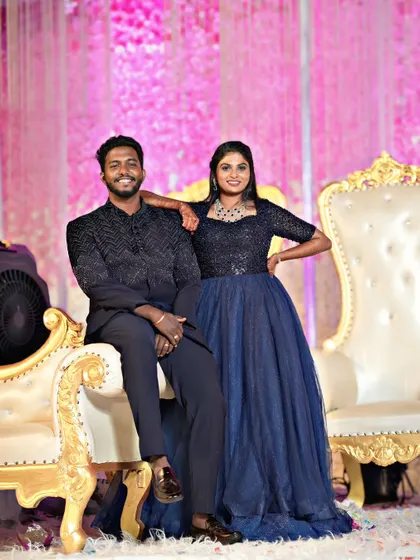 Posing for the camera, this couple shows how to coordinate in style. His black Jodhpuri and her navy gown are a perfect match for a grand reception.