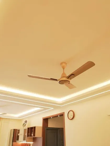 An elegant false ceiling design with multiple levels and recessed LED strips. This architectural feature adds depth and a sense of luxury to the living and dining area.