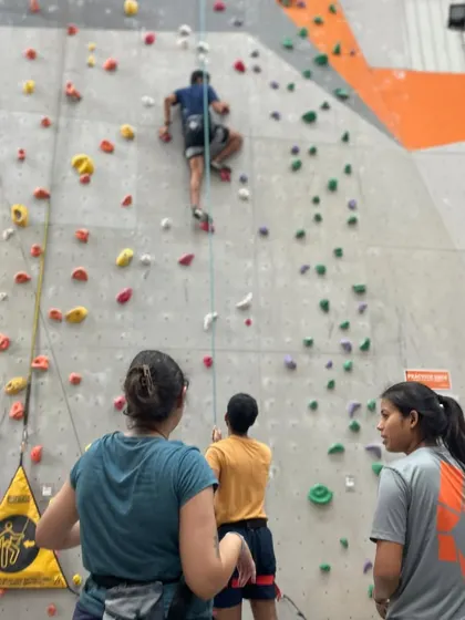 A group of climbers watches their friend on the wall. The supportive community is one of the best parts of climbing here.
