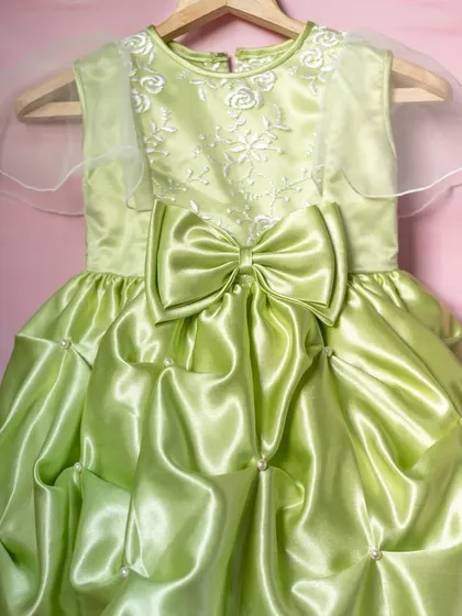 A closer look at the lime green satin bubble dress. The intricate gathering of the fabric and the pearl details create a truly unique and high-fashion piece.