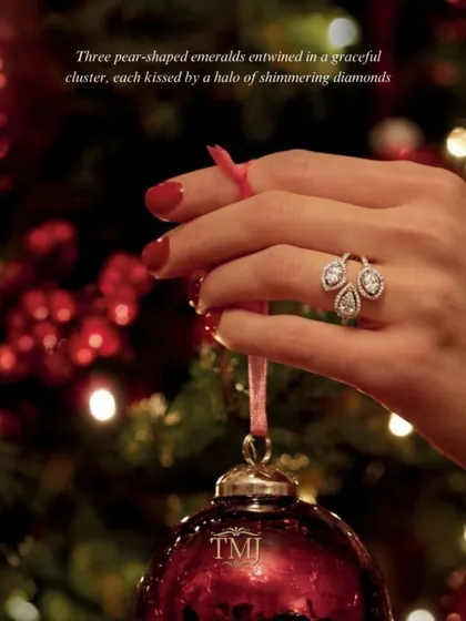 A quiet statement, made threefold. This unique ring features three pear-shaped emeralds entwined in a graceful cluster, each kissed by a halo of shimmering diamonds.