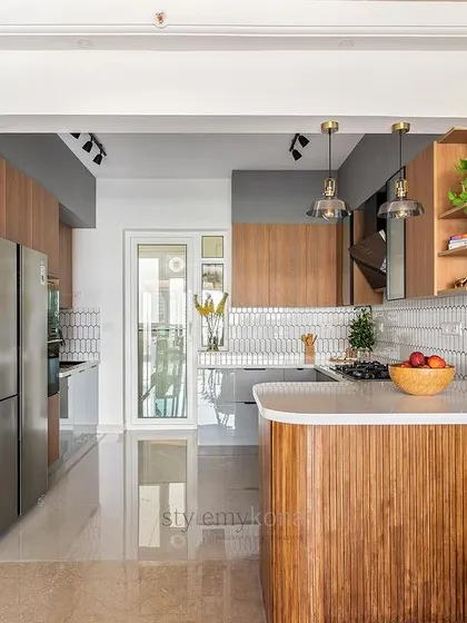 The arched entryway to the kitchen in our 'Tatvam' project creates a beautiful, soft transition from the dining area. The fluted wood island adds texture and warmth.