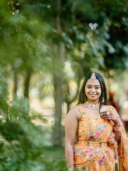 A beautiful portrait of a guest in a floral saree, enjoying the vibrant atmosphere of the Haldi.