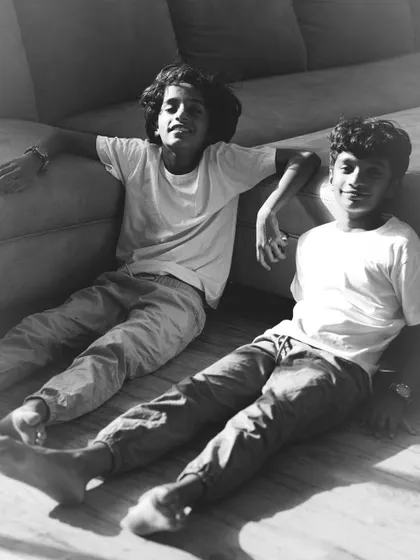 A relaxed portrait of two brothers taking a break from playing. Shooting in your home allows for these comfortable, natural poses that truly reflect their personalities without any forced smiles.