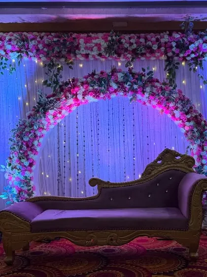 A simple yet elegant stage for an engagement or ring ceremony. I used a floral arch against a backdrop of white curtains and fairy lights, with a classic purple chaise lounge as the centerpiece.