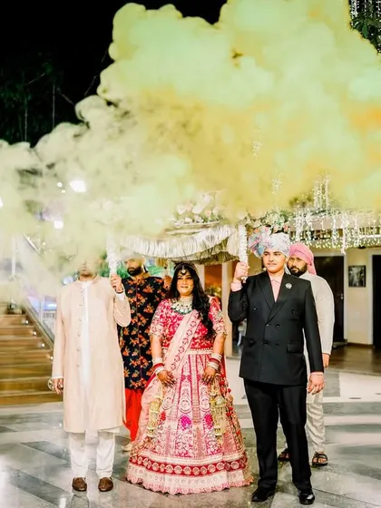 A grand bridal entry with a colorful smoke bomb creating a dramatic effect. This unique and vibrant entrance is a fantastic way to kick off the reception festivities.