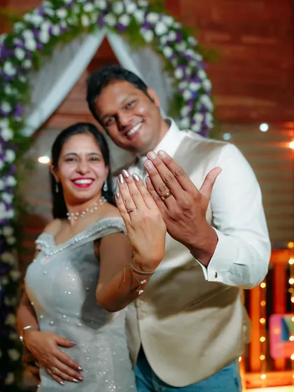 The happy couple showing off their new rings! This is a classic, joyful shot that celebrates their official engagement.