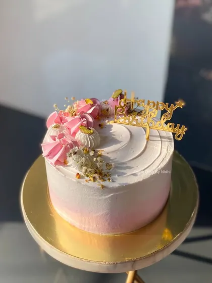 A pretty pink and white Rose and Pistachio cake. The delicate colors and simple decorations make this a beautiful and delicious choice for a birthday.