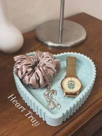 A customer's photo of our ribbed heart tray in a lovely light blue marble. It’s styled perfectly on a bedside table to hold a watch, necklace, and scrunchie.