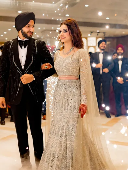 A grand entrance at a Sikh engagement party. The couple looks stunning as they walk in, ready to celebrate with their loved ones.