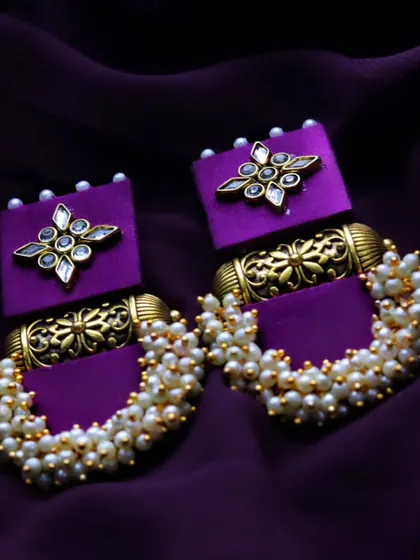 A slightly different angle of the handmade purple earrings, offering another clear view of their unique design and construction.