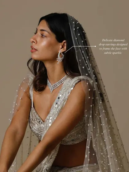 The complete bridal look is in the details. These delicate diamond drop earrings are designed to frame the face with a subtle, elegant sparkle, perfectly complementing the matching necklace.