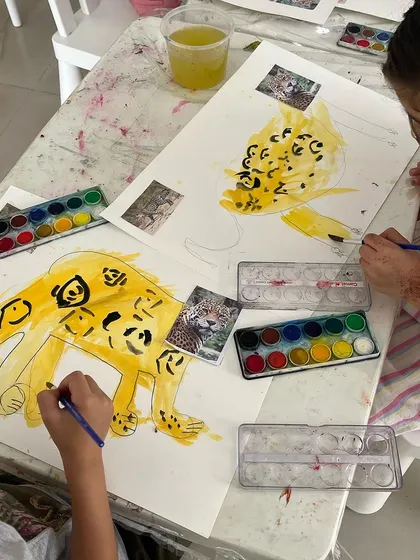 A closer look at our young artists painting leopards. Using reference photos helps them practice observational drawing skills in a fun and engaging way.