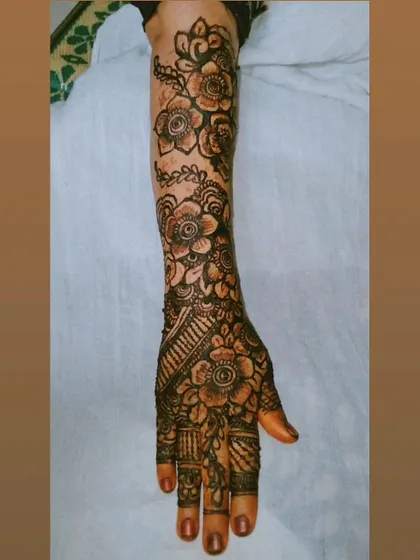 This design focuses on a cascade of flowers flowing down the arm. It's a great example of how floral patterns can be used to create a full bridal look that feels both romantic and sophisticated.