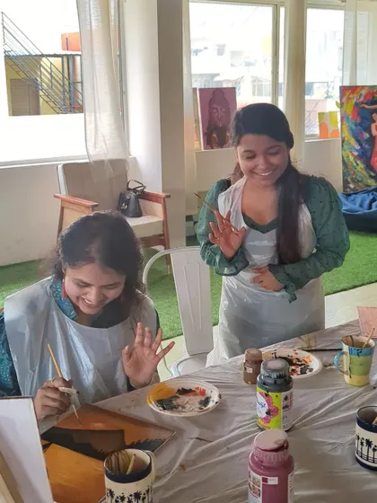 Two friends enjoying a painting session, laughing and creating together.