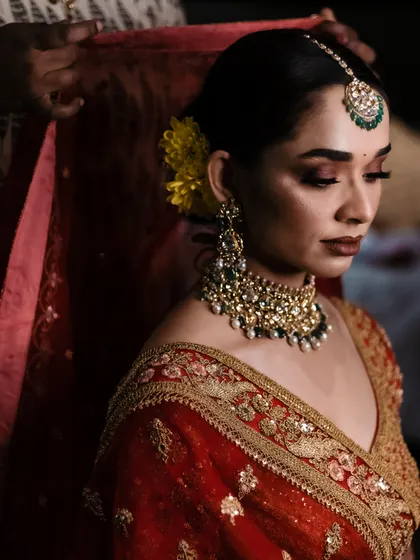 A quiet moment of preparation as the bride gets ready, her mother or a loved one adjusting her veil.