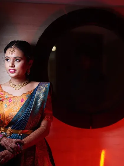 A beautifully composed shot of the bride-to-be Yoshitha. The dramatic lighting highlights her colorful outfit and the flawless finish of her traditional makeup look.
