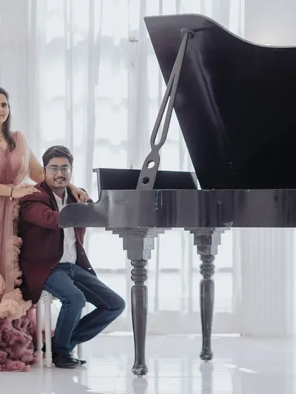 Another beautiful pose with the grand piano, showcasing the couple's connection in a sophisticated and classic setting.