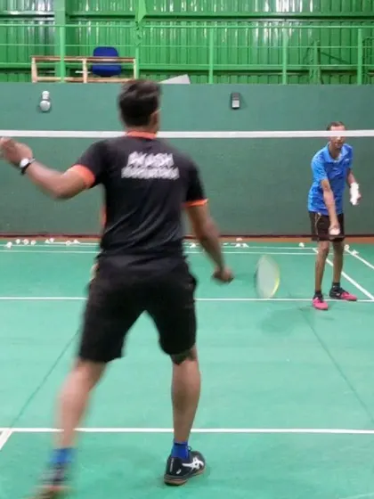 Personal attention is key to our coaching method. Here, one of our coaches provides one on one instruction, demonstrating the correct form for a net shot during an adult beginner badminton lesson.